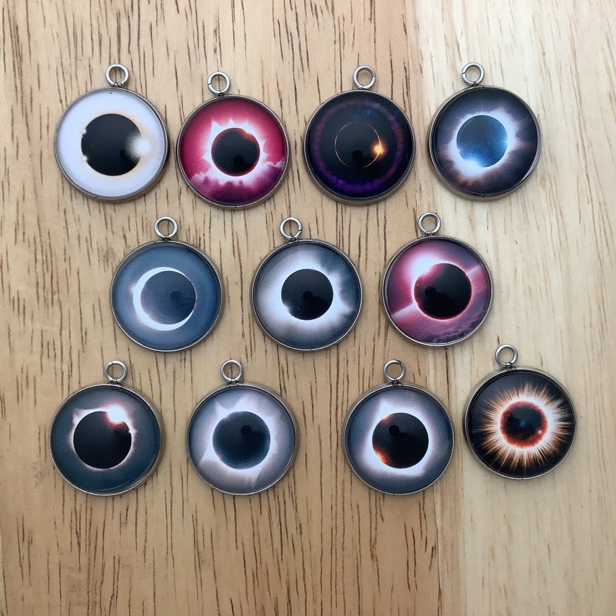 group of 11 charms featuring different photos of an eclipse