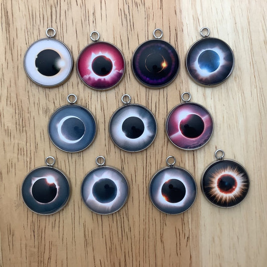 group of 11 charms featuring different photos of an eclipse