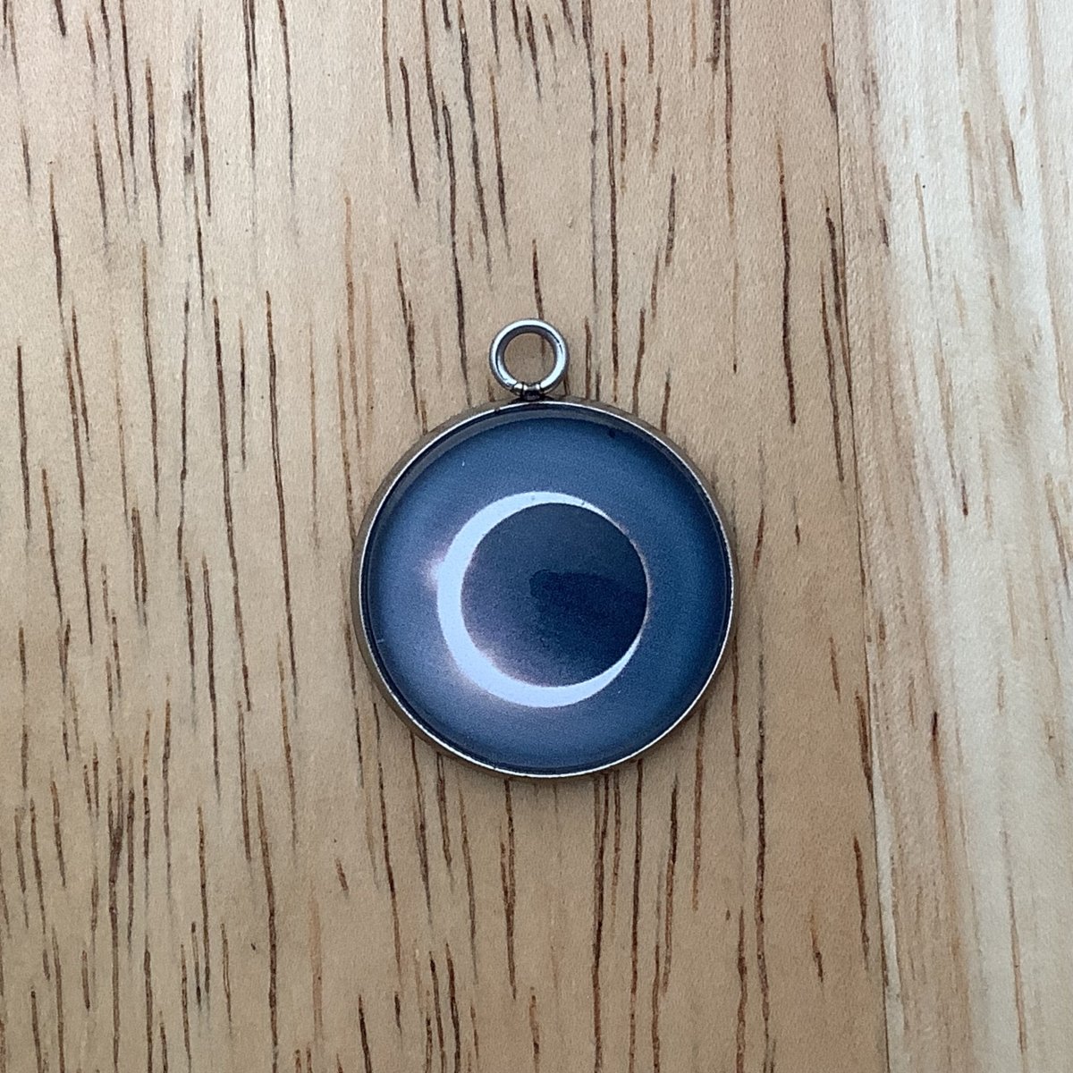 a charm depicting an eclipse