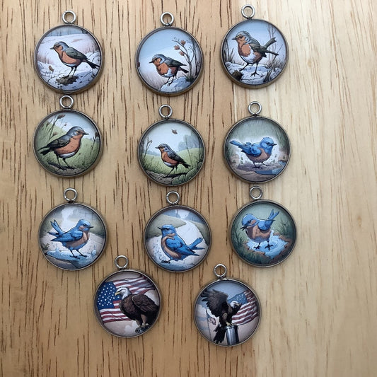 group of 11 charms depicting birds outside in the spring