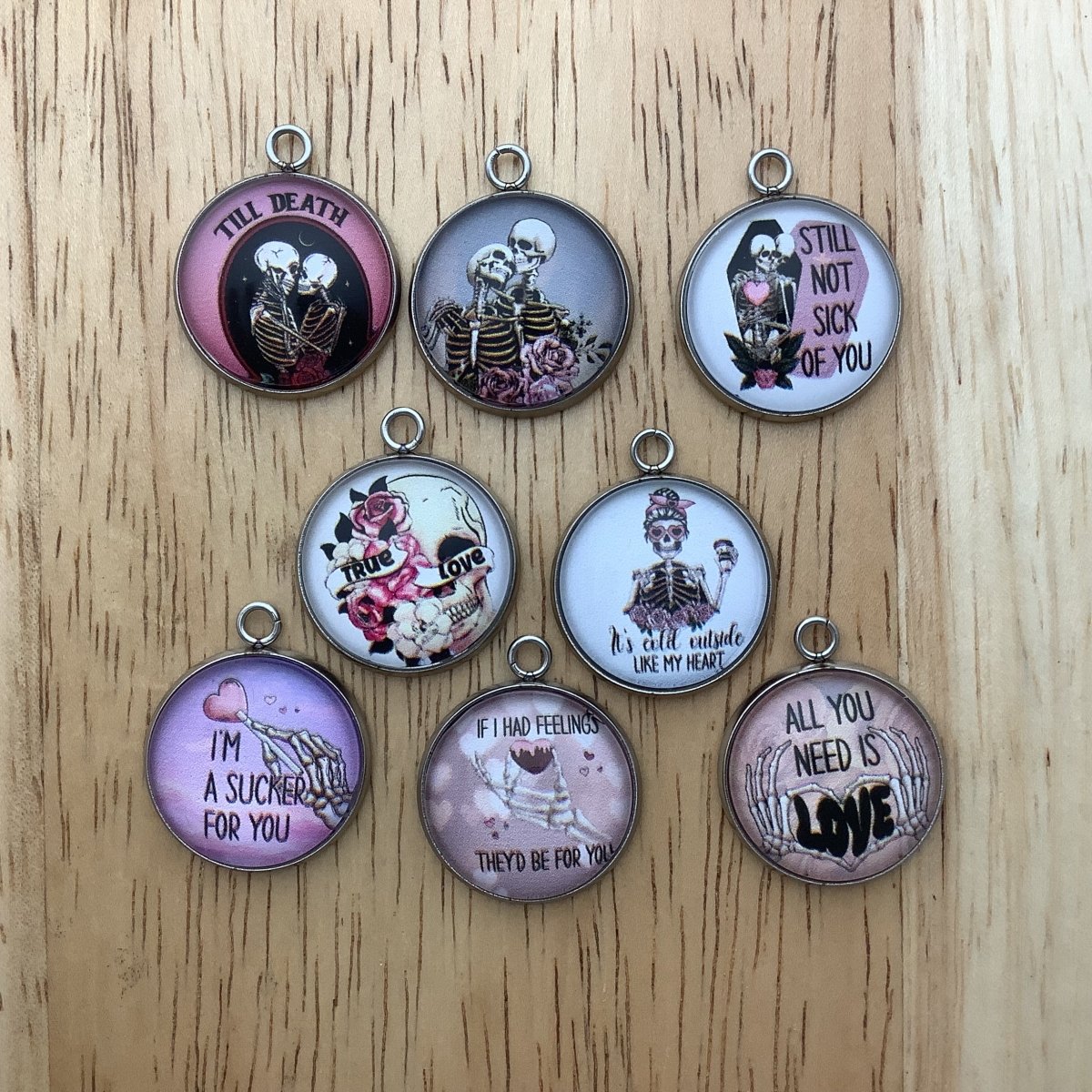 Set of 8 charms featuring skeletons in various poses celebrating their love of their loved one.