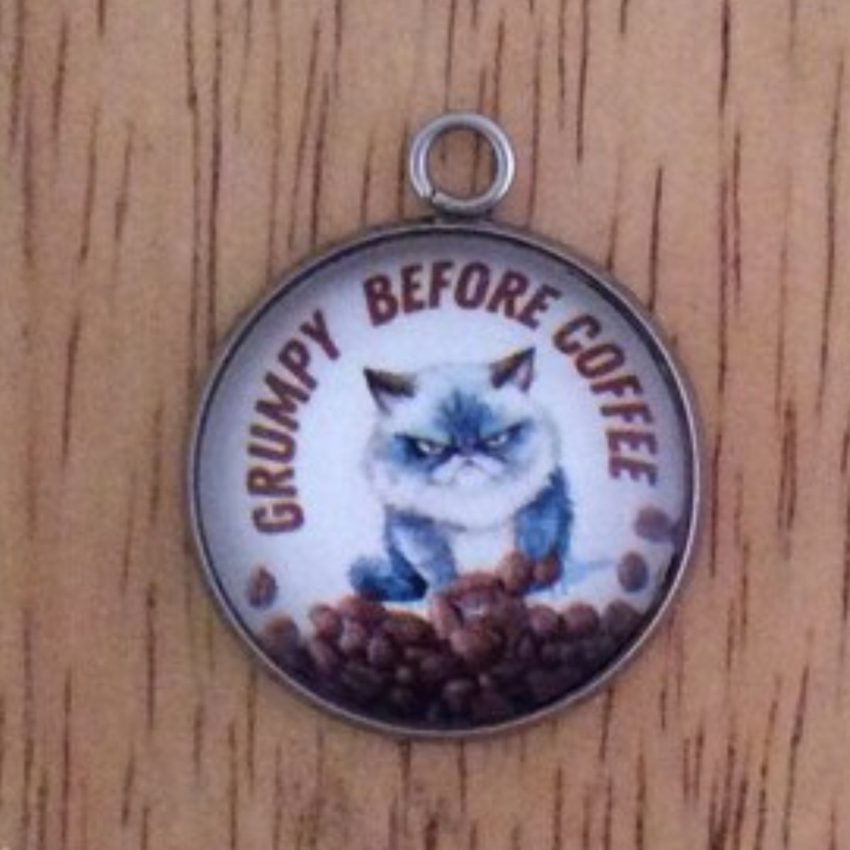 glass cabochon charm with a grumpy cat behind a pile of coffee beans and it says Grumpy Before Coffee