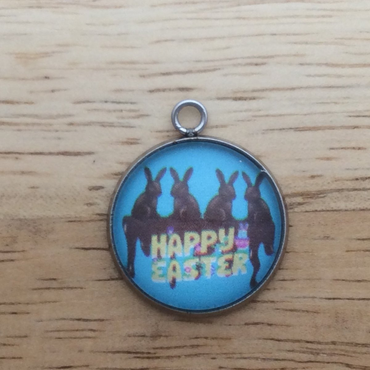 glass cabochon charm with 4 chocolate bunnies sitting on melting chocolate and says Happy easter