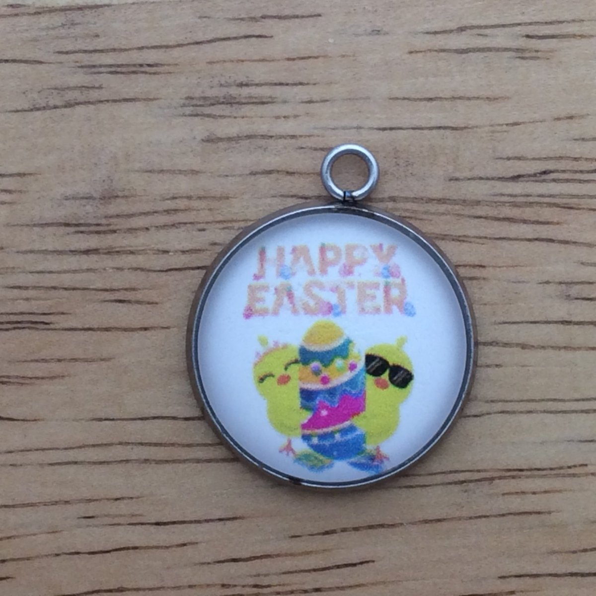 glass cabochon charm with two chicks hugging an easter egg. Says happy easter.