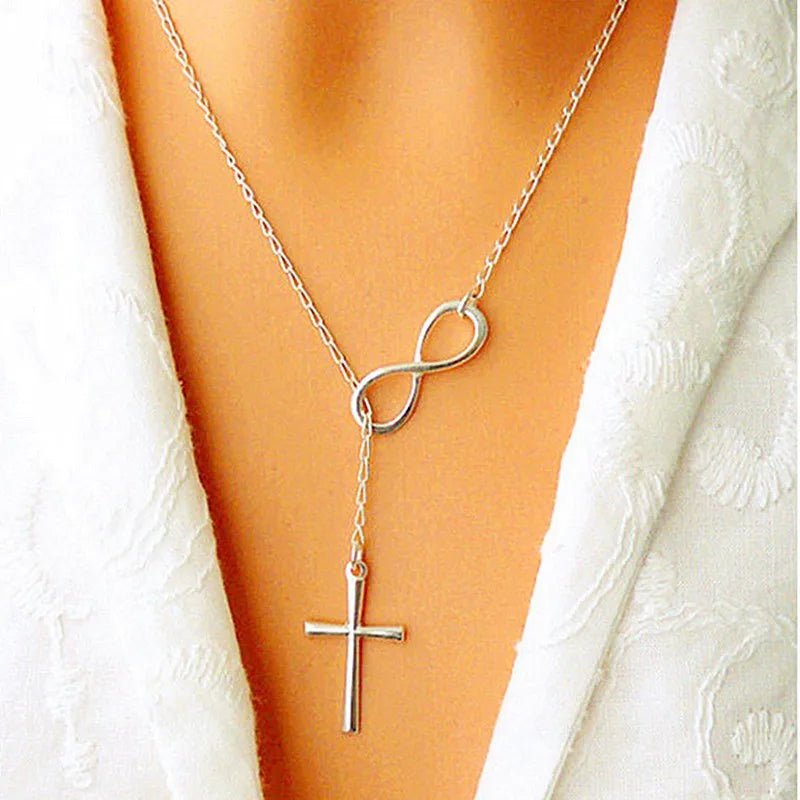 Neck shot of a person in a robe wearing a silver chain with an infinity charm and cross