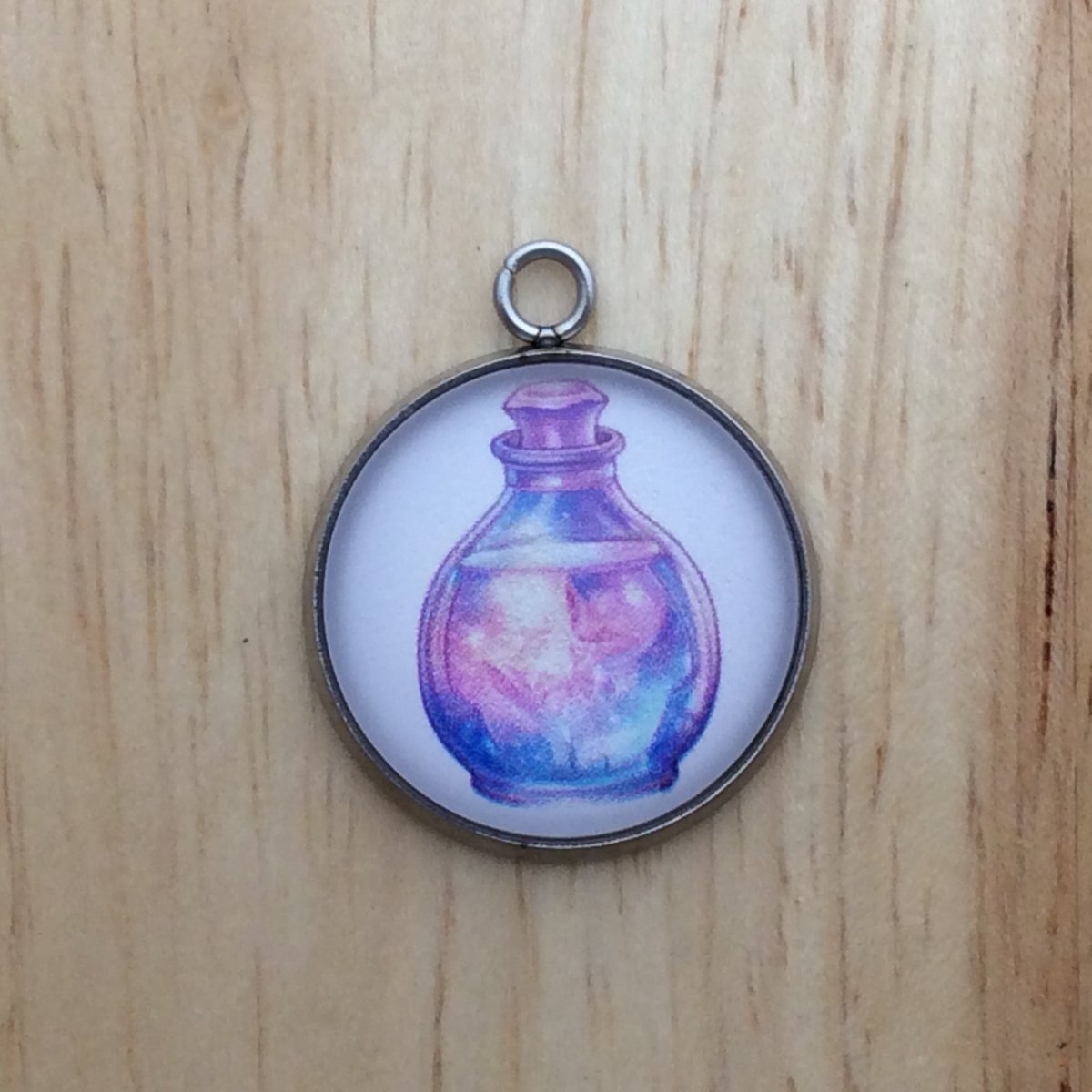 glass cabochon charm with a colorful fairytale potion bottle