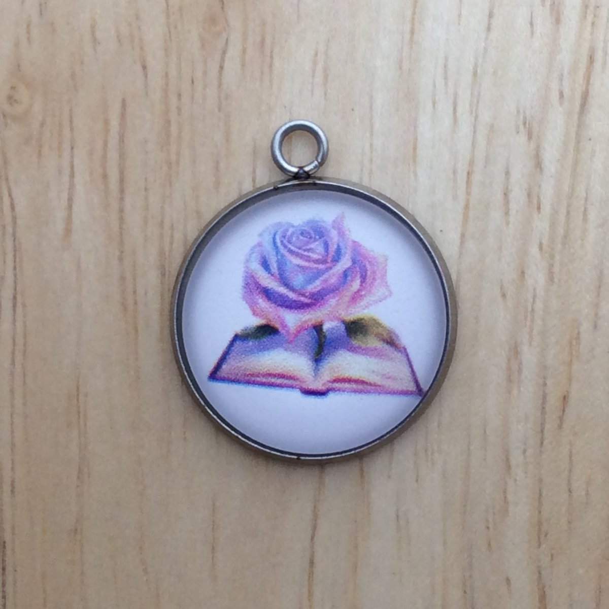 glass cabochon charm with a colorful fairytale book with a rose