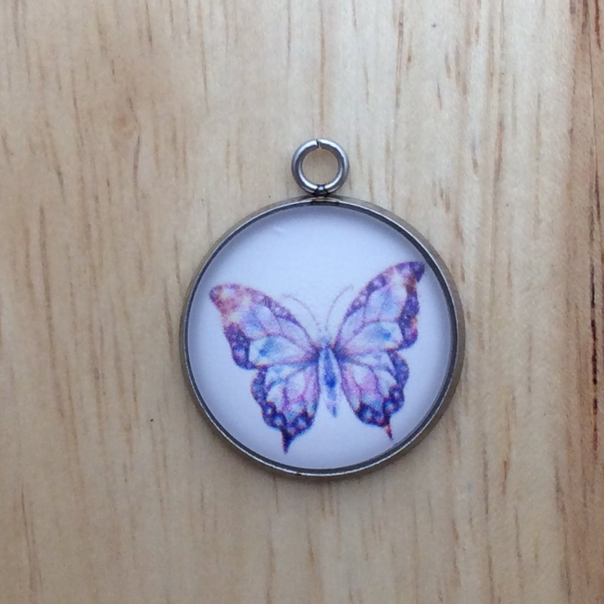 glass cabochon charm with a colorful butterfly