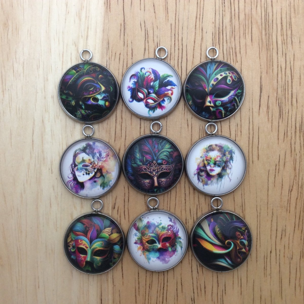 Set of 9 glass cabochon charms with various styles of colorful Mardi Gras masks