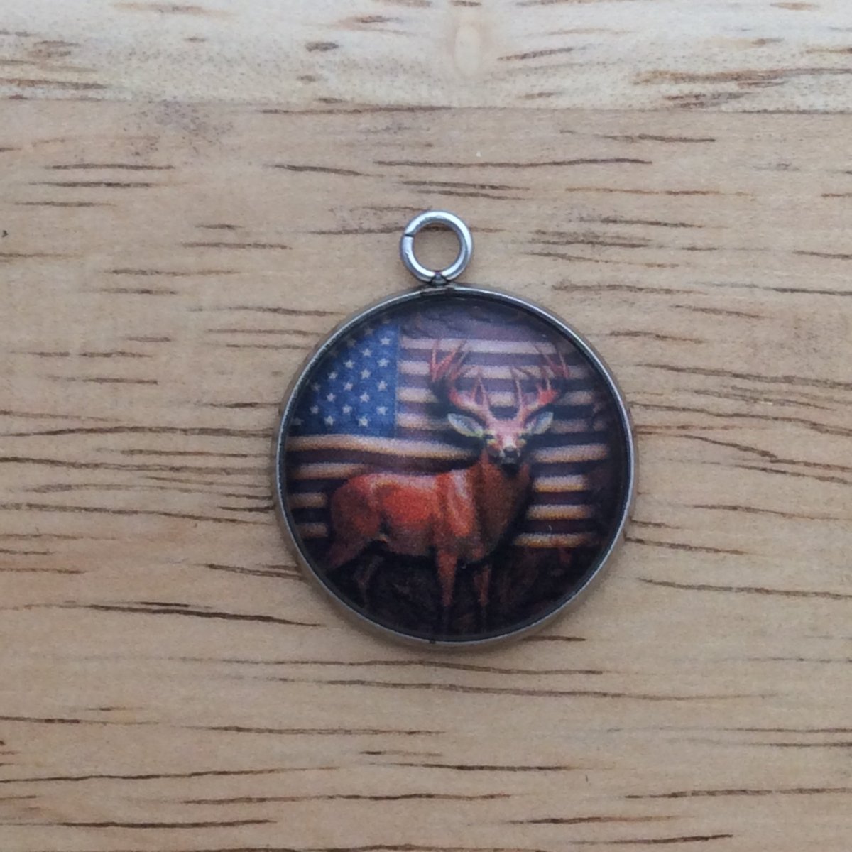 glass cabochon charm with a Buck in front of American flag