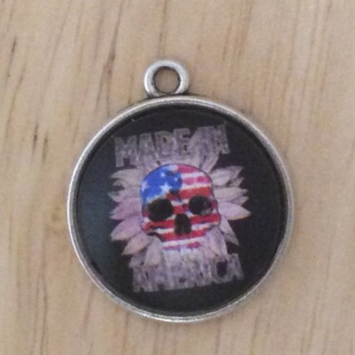 glass cabochon charm with an American flag skull that says Made in america