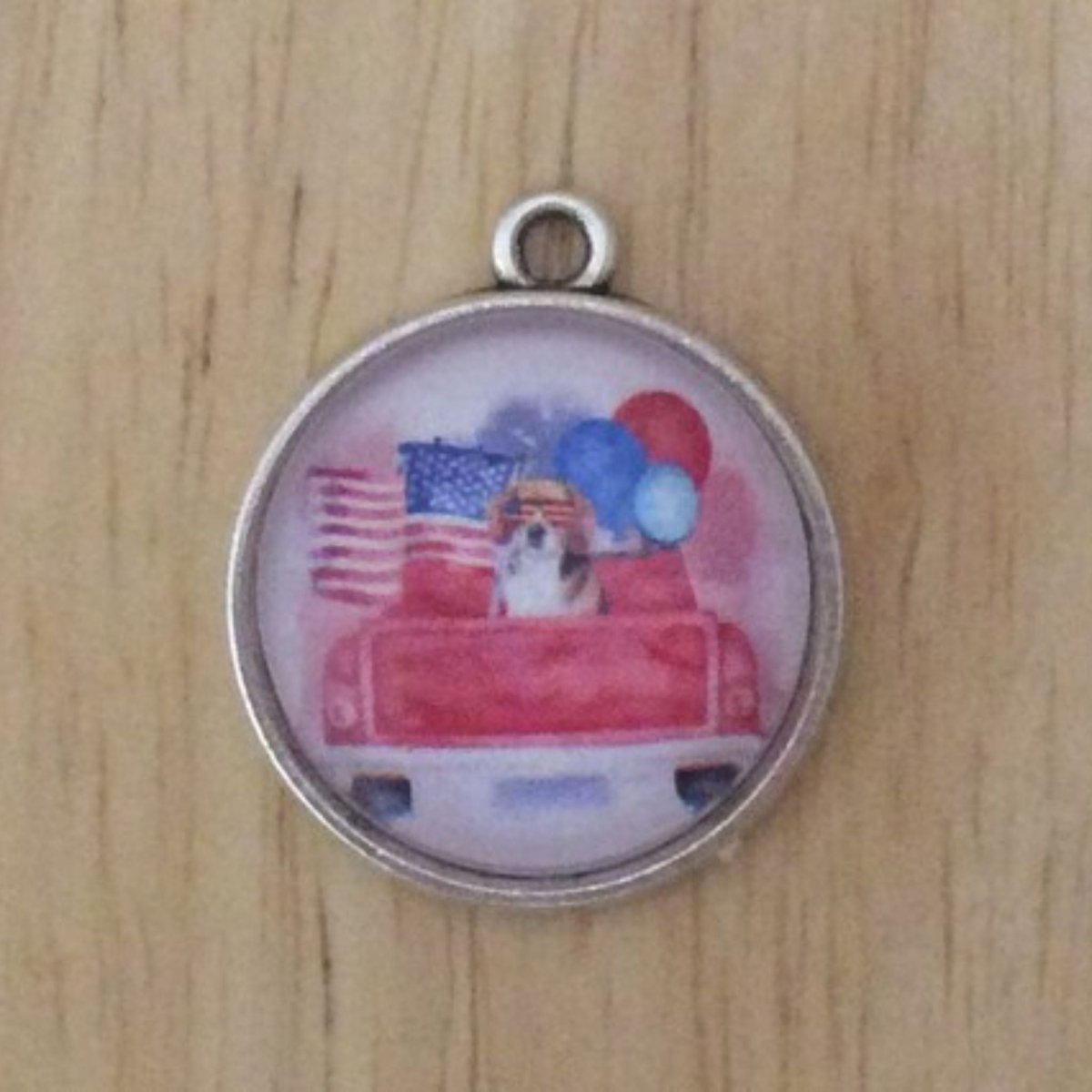 glass cabochon charm that shows a truck with Americans flag, balloons and dog with flag sunglasses