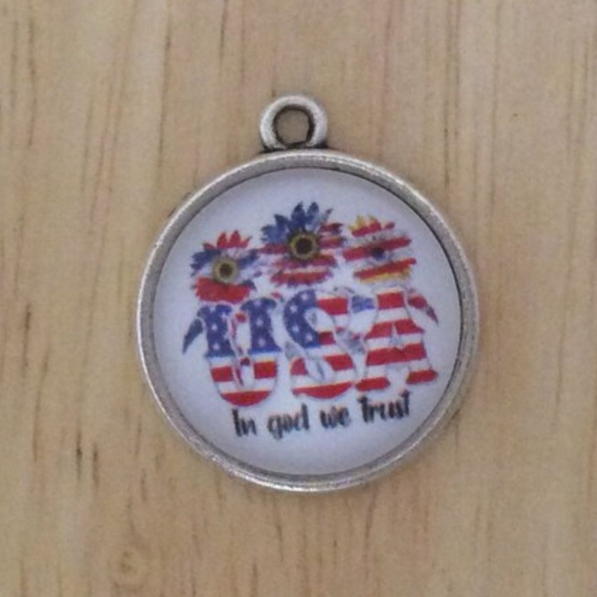 glass cabochon charm that has three red whit and blue sunflowers over the word USA in god we trust