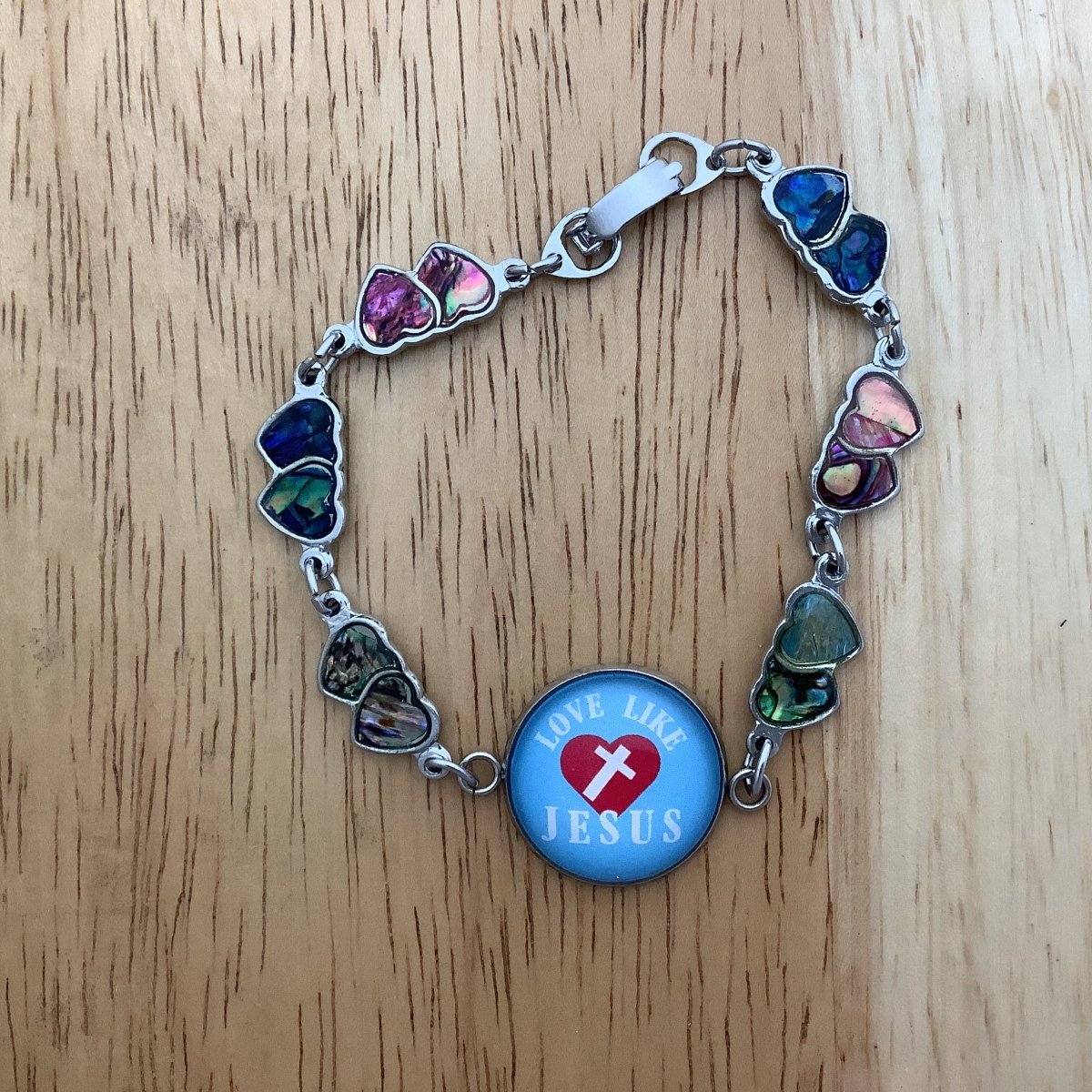 double paua heart charm bracelet with a glass cabochon charm stating 'Love like Jesus' as a centerpiece