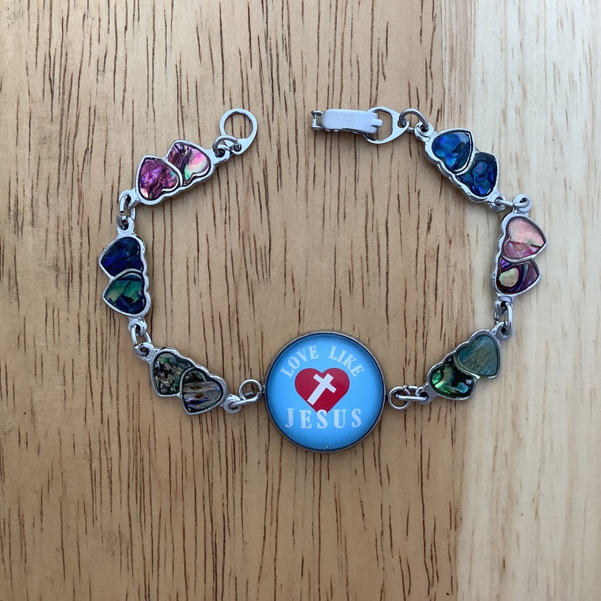 double paua heart charm bracelet with a glass cabochon charm stating 'Love like Jesus'as a centerpiece