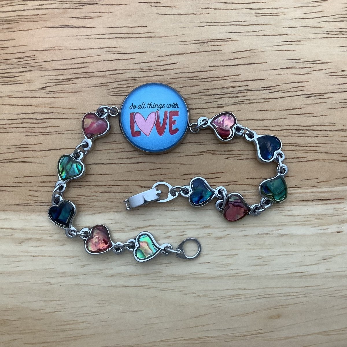 paua heart bracelet with the centerpiece charm stating 'do all things with love'