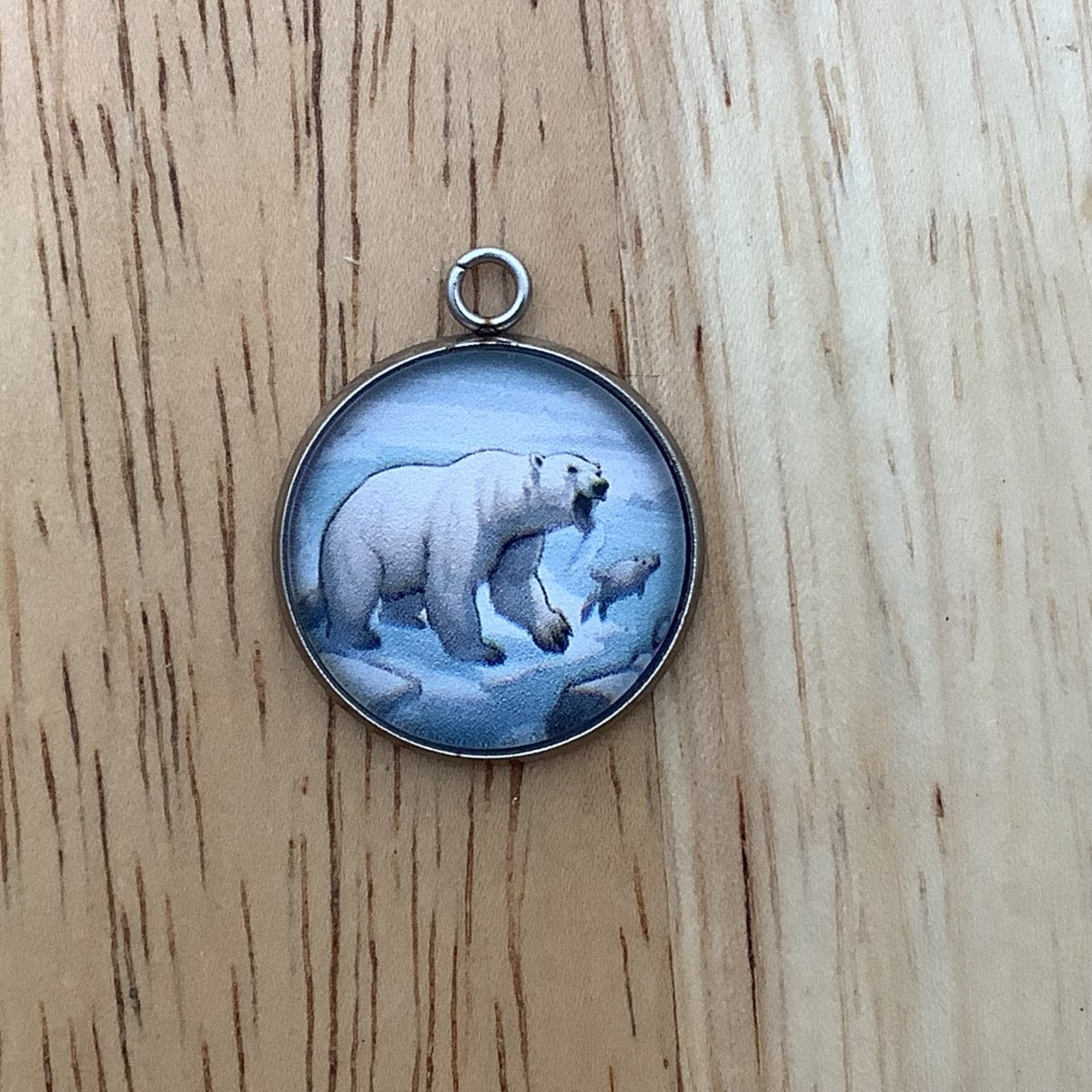 a charm depicting a polar bear with his mouth open and a seal jumping to safety