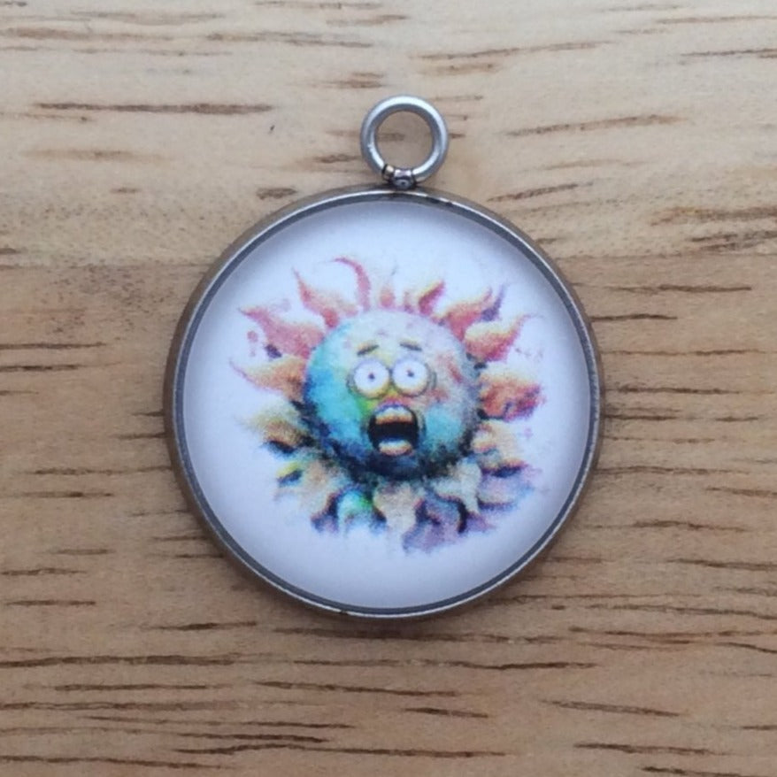 Glass cabochon charm with a funny faced, rainbow colored sun