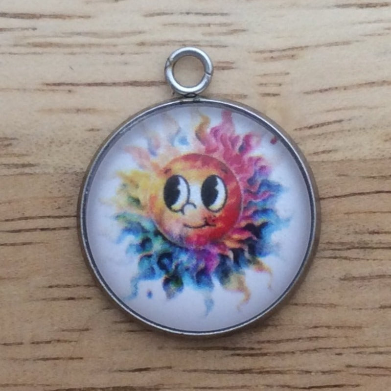 Glass cabochon charm with a smiling, rainbow colored sun