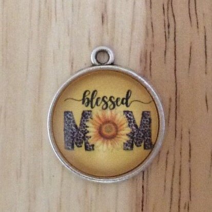 Glass cabochon charm that has a sunflower and says blessed mom.