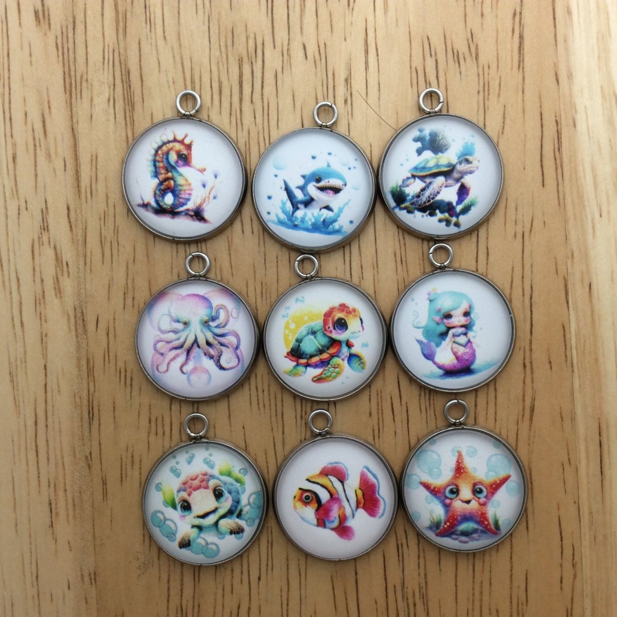 9 glass cabochon charms with images aof various saline creatures