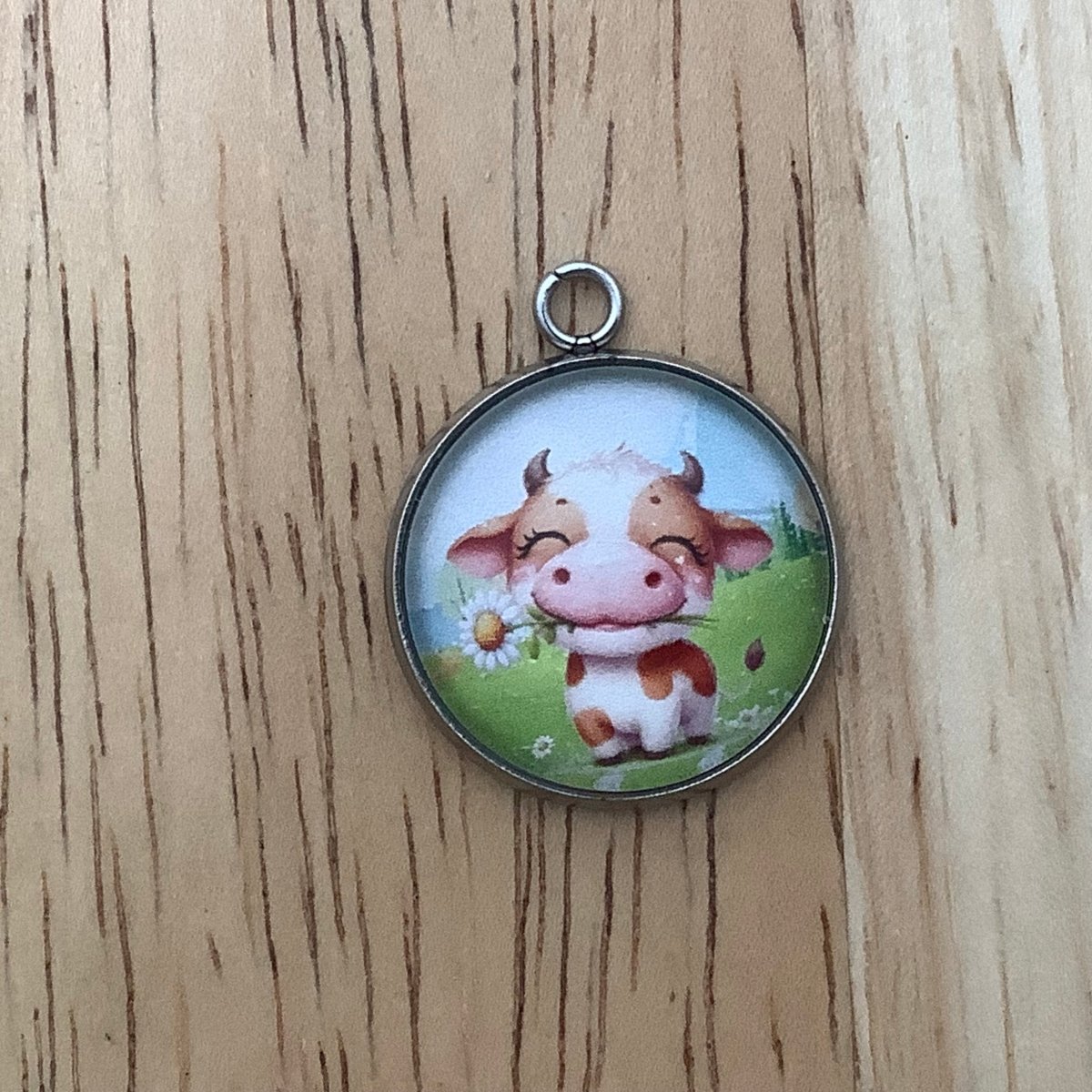 a cow holding a daisy in his mouth