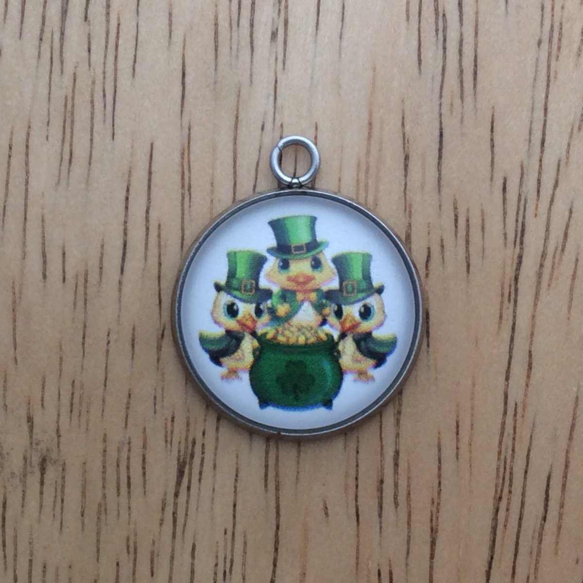 glass cabochon charm with three ducks in st Patricks clothing behind a pot of gold