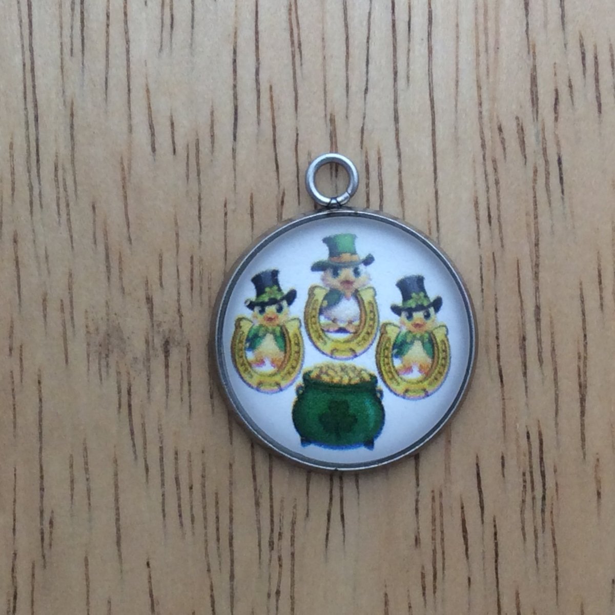 glass cabochon charm with Three ducks in st Patricks clothing behind horseshoes and a pot of gold