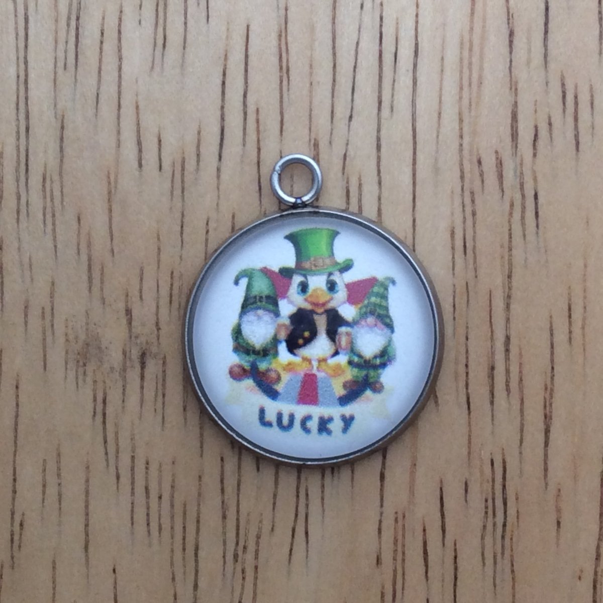 glass cabochon charm with a duck and 2 gnomes in st Patricks clothing in front of a Lucky horseshoe