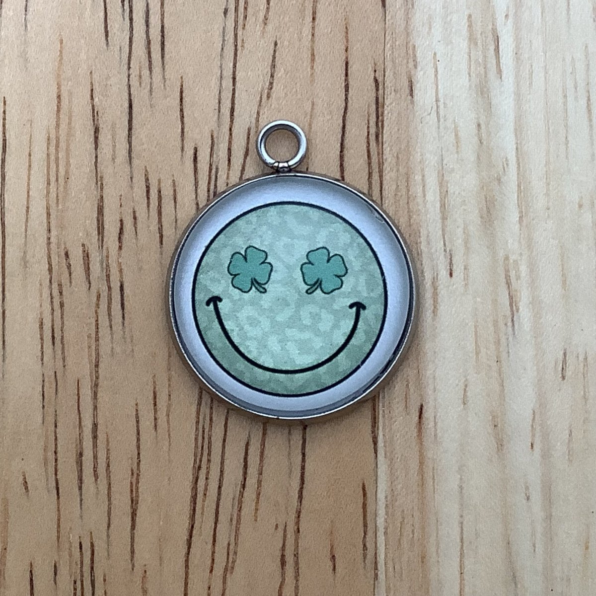 a green smiley face with 4 leaf clovers for eyes