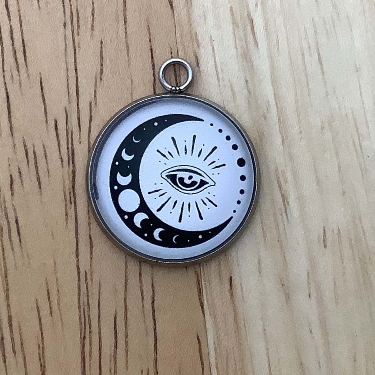 Charm featuring  moon phases in a moon sliver and an eye