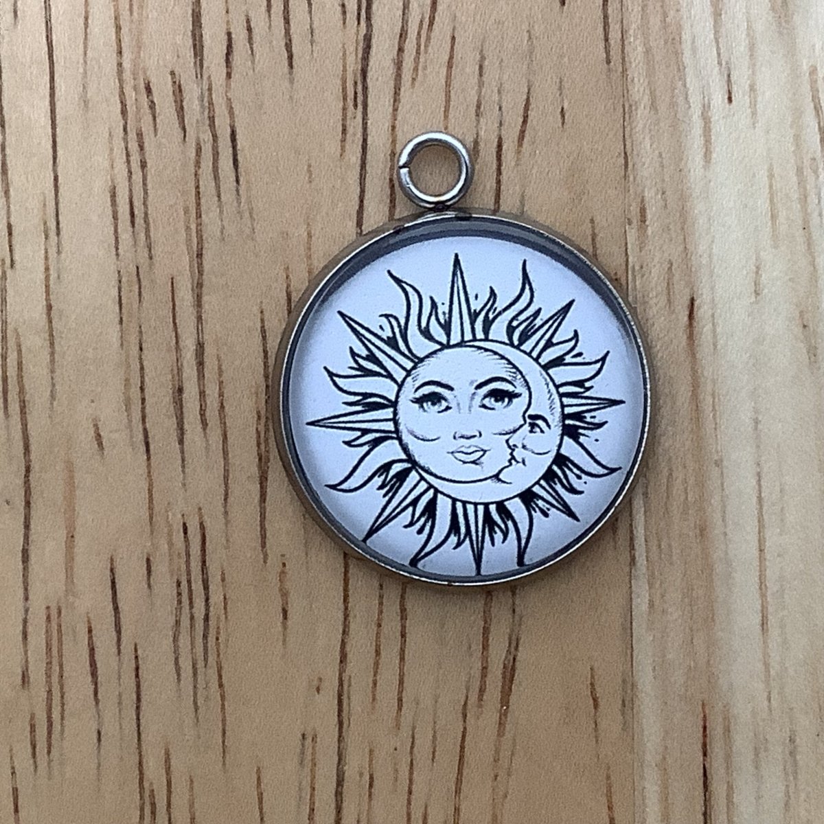 Charm featuring the sun and moon