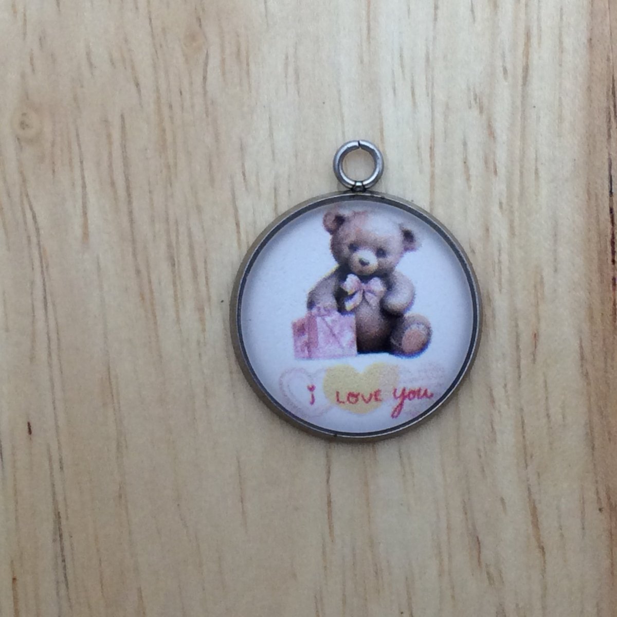 One glass cabochon charm that says I Love you with a teddy bear holding a present