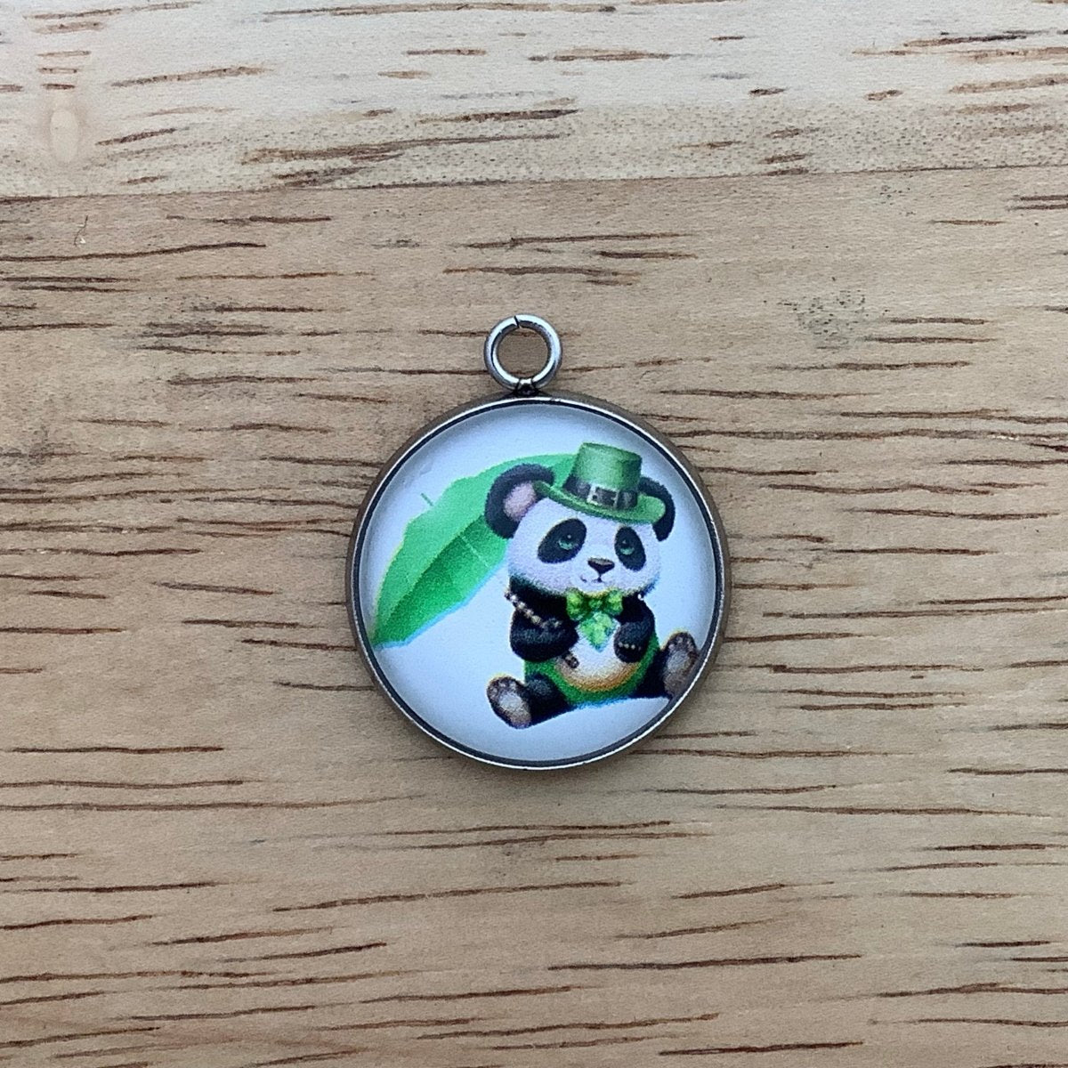 a panda with a green hat, parasol and neck ribbon